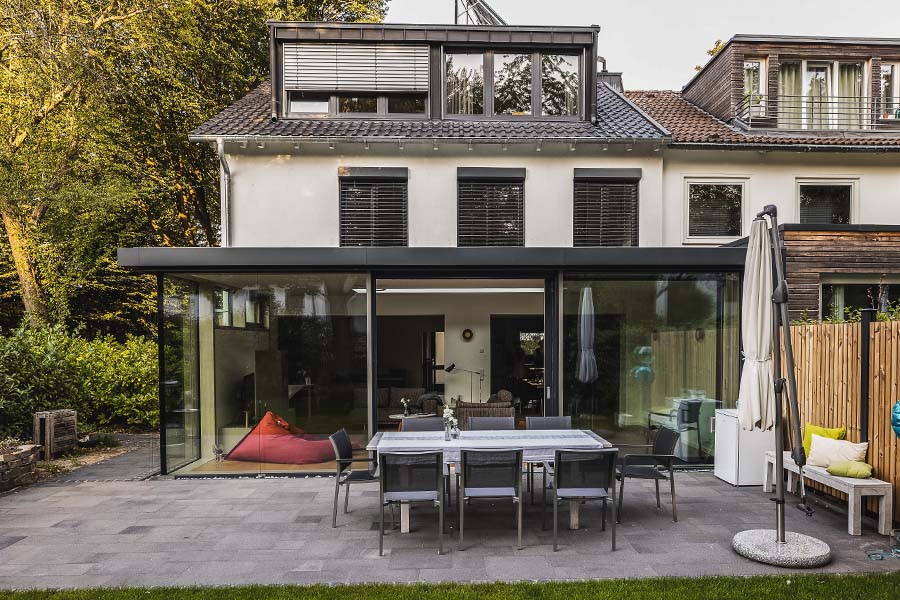 Design-Wintergarten mit großer Verglasung und Schiebetür zur Terrasse