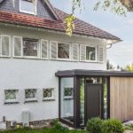 Moderner Anbau in Holz und Glas mit Eingangsbereich