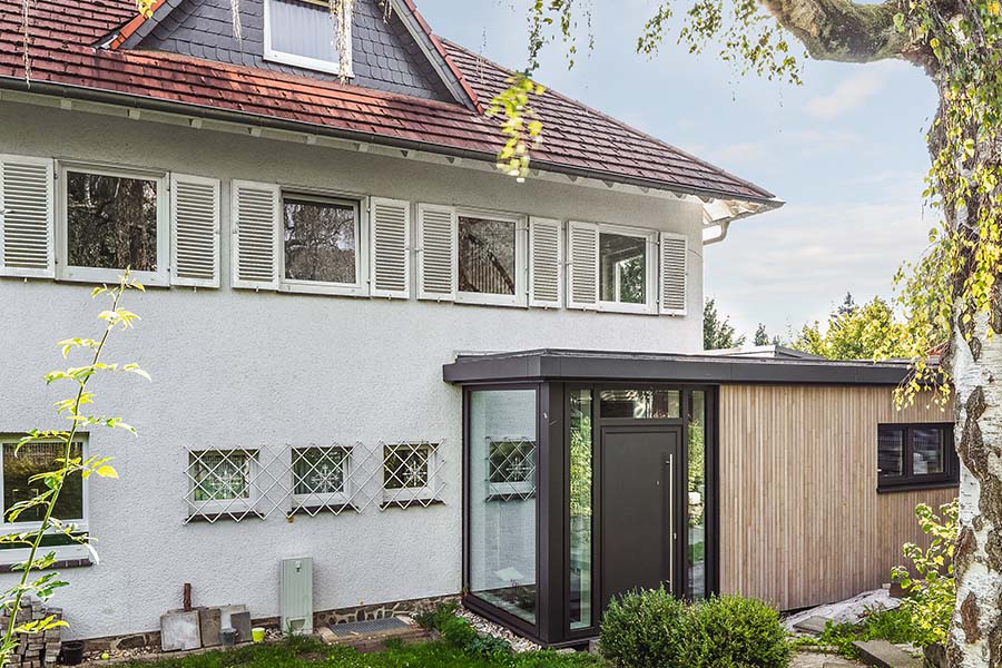 Moderner Anbau in Holz und Glas mit Eingangsbereich