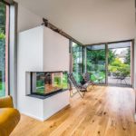 Anbau aus Holz und Glas mit Kamin