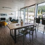 Wohn- und Essbereich in Ferienhaus mit großer Glasfassade und direktem, barrierefreiem Zugang zur Terrasse