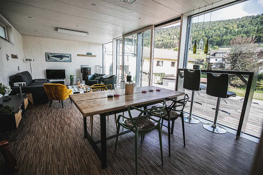 Wohn- und Essbereich in Ferienhaus mit großer Glasfassade und direktem, barrierefreiem Zugang zur Terrasse