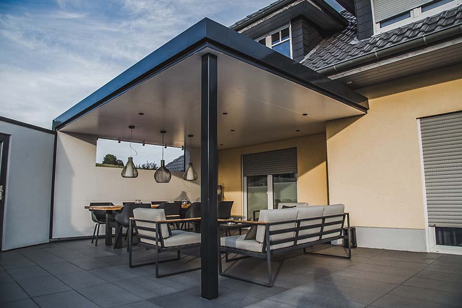 Geschützte Sitzecke durch ein Terrassendach mit geschlossener Wand, für ausreichend Helligkeit sorgt ein Oberlicht in der geschlossenen Wand.