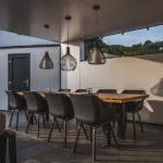 Stylischer Esstisch unter modernem Terrassendach