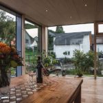 Esstisch in modernem Wintergarten mit Holzdecke