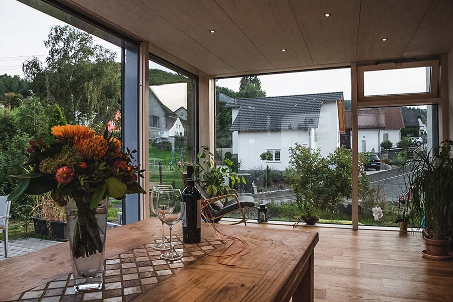 Esstisch in modernem Wintergarten mit Holzdecke