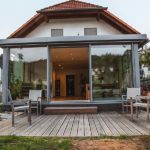 Wintergarten Holz-Aluminium mit geoeffneter Schiebetür zum Garten